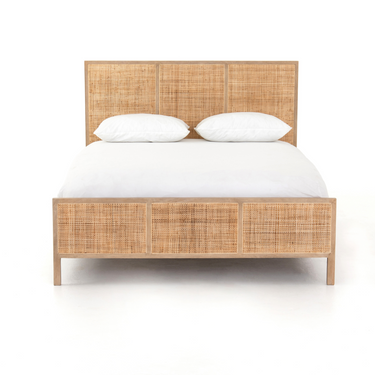 A bed with a solid mango wood frame, light brown woven cane headboard and footboard, and white bedding.
